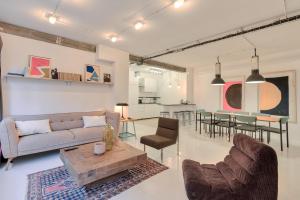 ein Wohnzimmer mit einem Sofa und einem Tisch in der Unterkunft Artist and Design Loft - 10 Guests - 5 Min From Metro in Paris