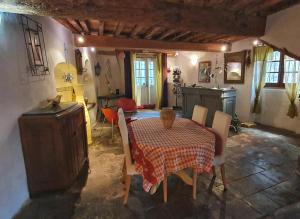 jadalnia ze stołem i krzesłami oraz kuchnia w obiekcie Orangerie de Cardet - Maison d'hôtes - B&B w mieście Cardet