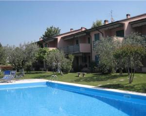 a large swimming pool in front of a house at APARTMENT ORTENSIA - Regarda Travel in Lazise