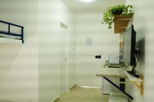 a kitchen with white walls and a white door at Enseada Village Guarujá in Guarujá