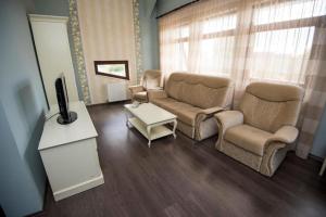 a living room with two chairs and a tv at Pensiunea 1 Mai in Baile Unu Mai