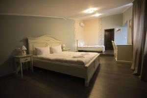 a bedroom with a large bed and a table with a bed sidx sidx sidx at Pensiunea 1 Mai in Baile Unu Mai