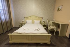 バイレ・ウヌ・マイにあるPensiunea 1 Maiのベッドルーム1室(白いベッド1台、白いタオル2枚付)