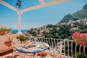 uma mesa e cadeiras numa varanda com vista para positano em Villa Mary Suites em Positano