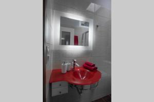 a bathroom with a red sink and a mirror at Ioanna Bayview Luxury Apartment in Ierápetra