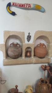 un estante con varias ollas de barro en una pared en TRADITIONAL HOUSE MARIA, en Azoyirás