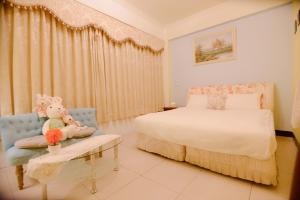 una camera con un letto e un orsacchiotto sul tavolo di 旅行者之家精緻漫旅-近火車站 a Città di Hualien