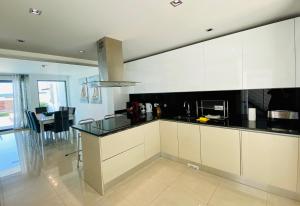 a kitchen with white cabinets and a black counter top at Albuhera by Check-in Portugal in Albufeira