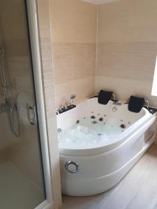 a white bath tub in a bathroom with a shower at Chez Aurel & Manu in Sainte-Marie-aux-Mines