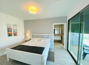 a white bedroom with a bed and a balcony at Albuhera by Check-in Portugal in Albufeira