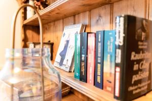 a row of books sitting on a shelf at Luettliv-Huus I in Wyk auf Föhr