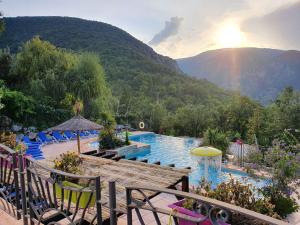 a pool with chairs and a view of a mountain at Camping Bellevue in Ria