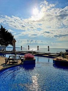 a swimming pool with people walking on the beach at Peter Hotel in Ravda