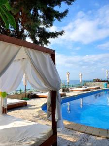 a pool with umbrellas and the ocean in the background at Peter Hotel in Ravda