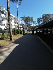 a sidewalk in front of a building with trees at Apartment LILY - Baltic Park Pogorzelica in Pogorzelica