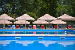 - une piscine avec des chaises longues et des parasols dans l'établissement Complex Mediteranean Mamaia, à Mamaia