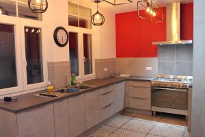 a large kitchen with a clock on the wall at L'esperluette in Spa