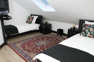 a bedroom with two beds and a rug at L'esperluette in Spa