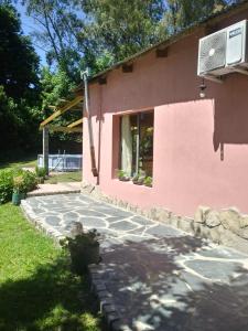a pink house with a stone walkway in front of it at Rancho Apar T - in Tandil +118 photos