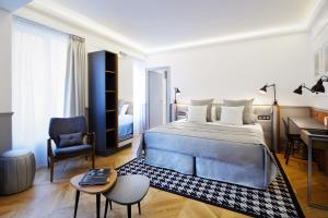 1 dormitorio con cama, escritorio y silla en Hotel Petit Lafayette, en París