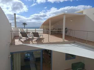 Un balcón con sillas y vistas al océano. en Villa AMALIA, en Costa Calma