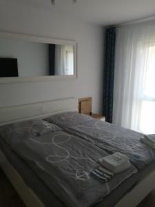 a bed in a bedroom with a mirror on it at Apartment LILY - Baltic Park Pogorzelica in Pogorzelica +61 photos