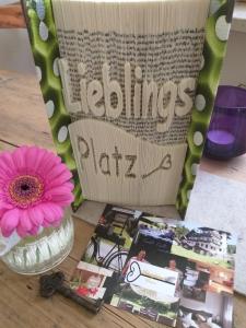 a table with a vase with a flower and a magazine at Pension Schatzkisterl in Zwiesel