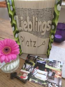 einen Tisch mit einer Vase mit einer Blume und einer Zeitschrift in der Unterkunft Pension Schatzkisterl in Zwiesel
