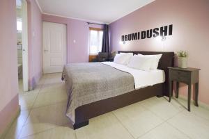 a bedroom with a large bed with a sign on the wall at Cadushi Apartments in Oranjestad