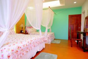 a bedroom with two beds with mosquito nets at Spring Garden Homestay in Hualien City