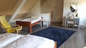 a bedroom with a bed and a desk and a chair at B&B de Oude Hofstee in Maasdam