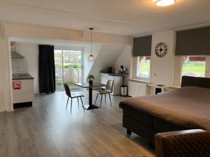 a bedroom with a bed and a table and chairs at Slapen bij de Buurvrouw in Castricum