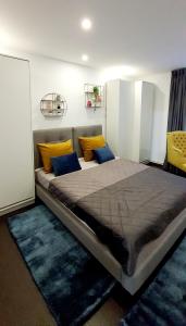 a bedroom with a large bed with yellow and blue pillows at ApartHotel Marasesti in Suceava