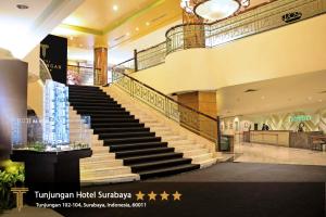 un grand hall avec des escaliers dans un centre commercial dans l'établissement Tunjungan Hotel, à Surabaya