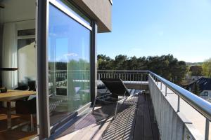 a balcony with glass doors and a table and chairs at DünenResort Ostseebad Binz in Binz