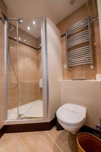 La salle de bains est pourvue d'une douche, de toilettes et d'une baignoire. dans l'établissement Victus Apartamenty, Apartament Liczi, à Sopot