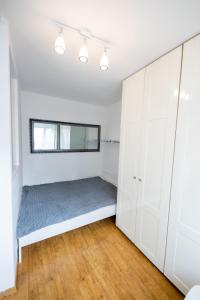 - une chambre avec des placards blancs et un lit dans l'établissement Victus Apartamenty, Apartament Liczi, à Sopot