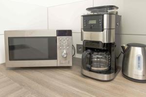 a microwave and a coffee maker on a counter at Stadtwohnung am Alleenring in Kirchheim unter Teck