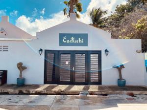 a white building with a sign that reads goodwill at Cadushi Apartments in Oranjestad