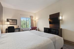 a hotel room with a bed and a flat screen tv at OYO Townhouse Orlando West in Orlando