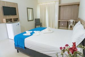 a bedroom with a large bed with towels on it at Portal do Sol Lençóis Pousada in Barreirinhas