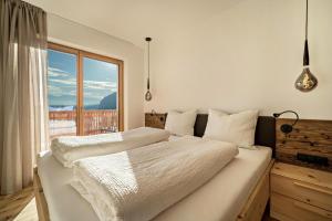 a bedroom with a large bed with a large window at Apt Fichte - Nockerhof in Andrian