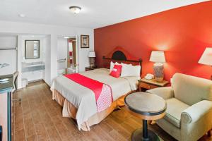 ein Hotelzimmer mit einem Bett und einem Stuhl in der Unterkunft OYO Hotel Blytheville AR I-55 in Blytheville