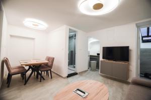 a living room with a dining room table and a television at Villa San Antonio 3-PALADA in Baška