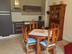 cocina con mesa de madera y sillas en una habitación en Jardin de Palme, en Lapalme