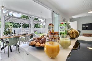 a table with a plate of food and two glasses of orange juice at Villa Zanzibar - 4 chambers, piscine privée, plage à pied, idéale pour découvrir le nord Caraibe in Case-Pilote