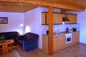 a kitchen with a living room with a couch and a table at Ferienhof Budach - Landurlaub vor den Toren Flensburgs in Handewitt