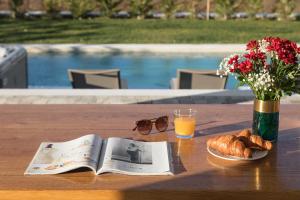 a table with a book and a glass of orange juice and bread at Villa Edoardo by Villas Holiday in Vižinada