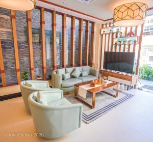 a living room with furniture and a tv at Avoca Inn in Hulhumale
