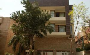 a building with a palm tree in front of it at East End Retreat in New Delhi